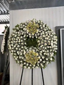 Τρίποδο στεφάνι πολυτελείας με λευκά άνθη και λευκά τριαντάφυλλα για κηδεία.