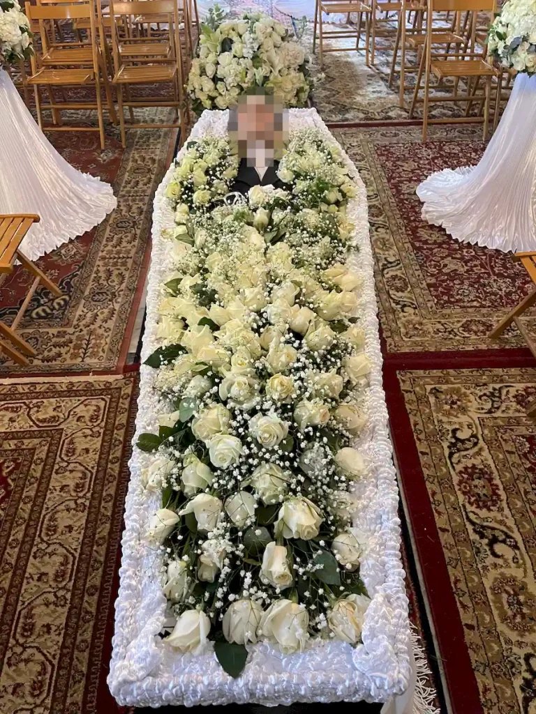 Στολισμός φέρετρου πολυτελείας με λευκά άνθη και λευκά τριαντάφυλλα.