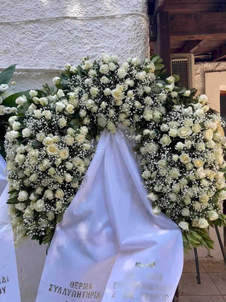 Τρίποδο στεφάνι πολυτελείας με λευκά άνθη και λευκά τριαντάφυλλα για κηδεία.