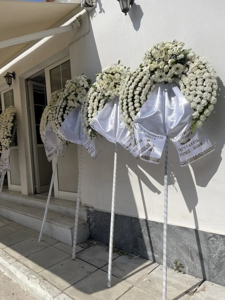 Στεφάνια κηδείας με λευκά άνθη και λευκά τριαντάφυλλα.